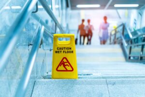 A yellow wet floor sign used to prevent injuries on slippery surfaces