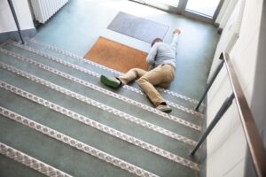 Someone lying at the bottom of the stairs after falling.